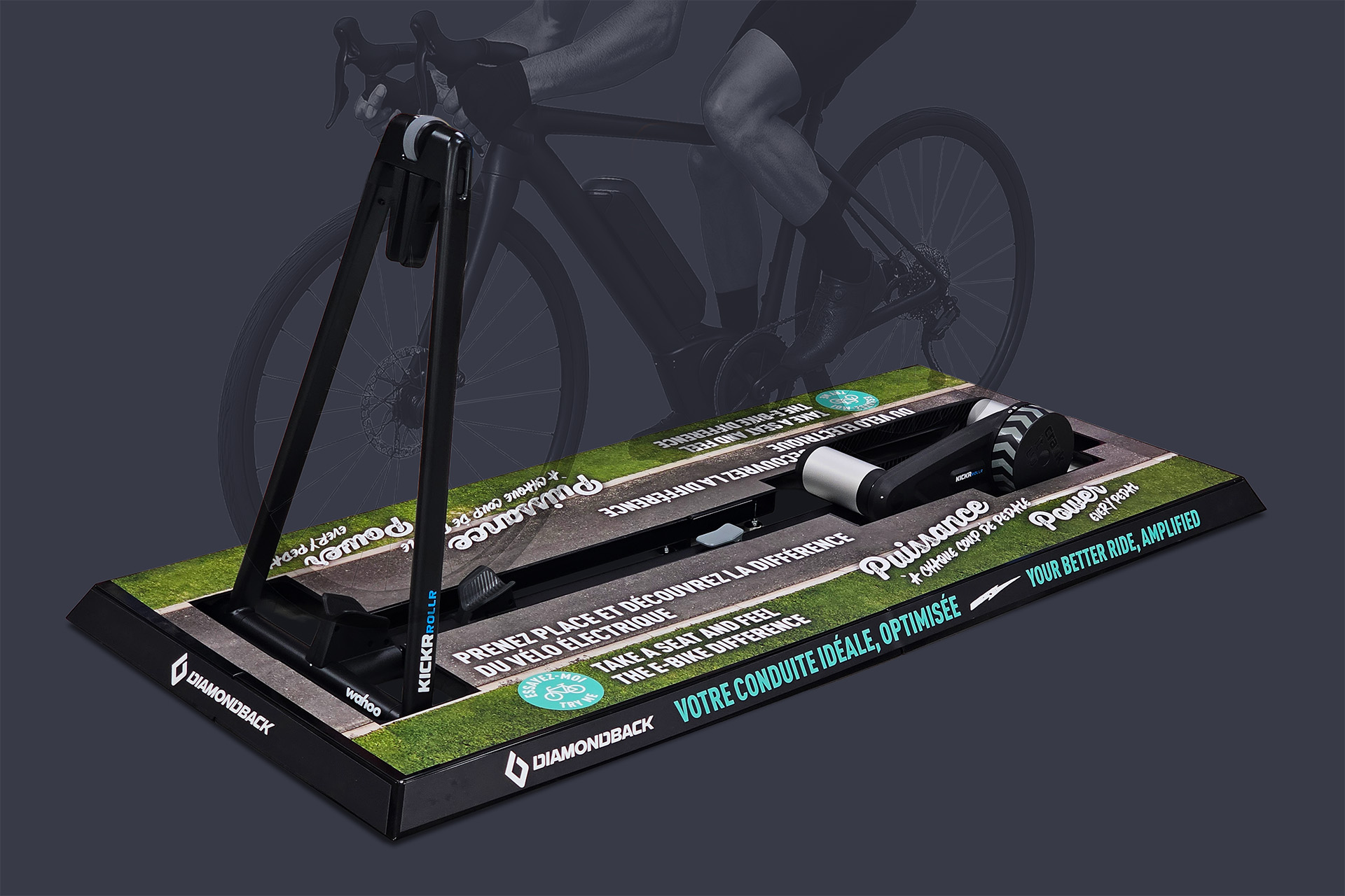 Modular steel platform with printed magnetic graphics displaying the Diamondback brand, surrounding a bicycle roller trainer to allow in‑store eBike test rides at Canadian Tire.