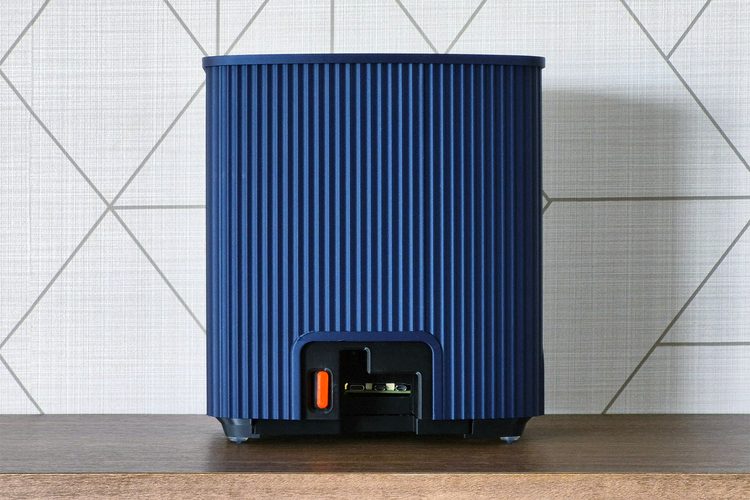 Back view of the blue ridged enclosure with a rounded cut-out at the base showing the Pi's small connectors and an orange power-button tab.