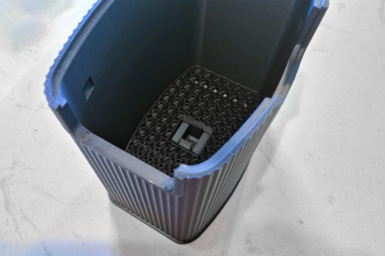 Looking down into the blue ridged shroud, with the black gyroid dust screen seated inside and a square cutout at its centre.